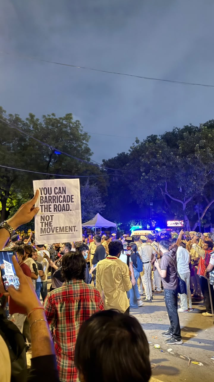 Wide crowd shot at Jantar Mantar at night, police and protesters facing off